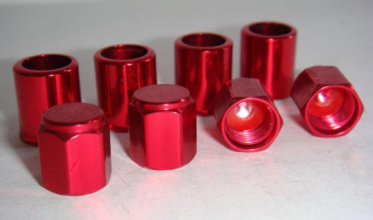 Set of 4 red aluminum alloy tire valve stem sleeves and hex top cap.