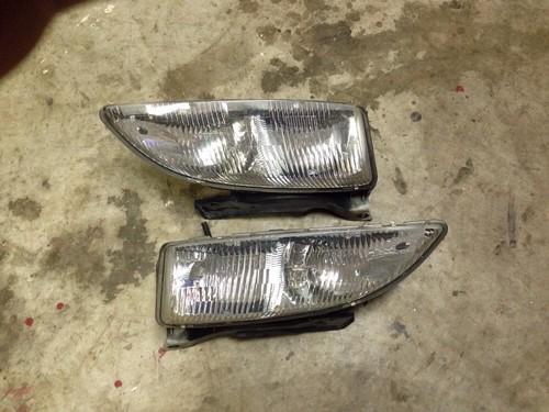 95 96 97 98 99 chevy cavalier headlights w/ mounting brackets attached