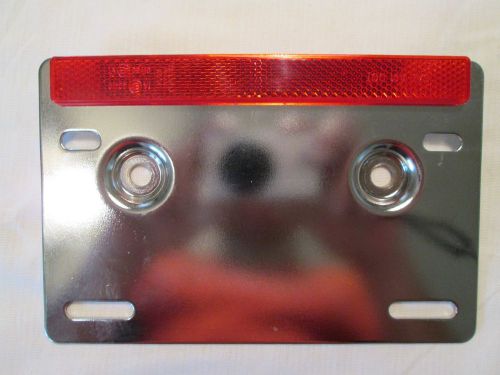 Universal licence plate bracket for motorcycle with dot reflector.