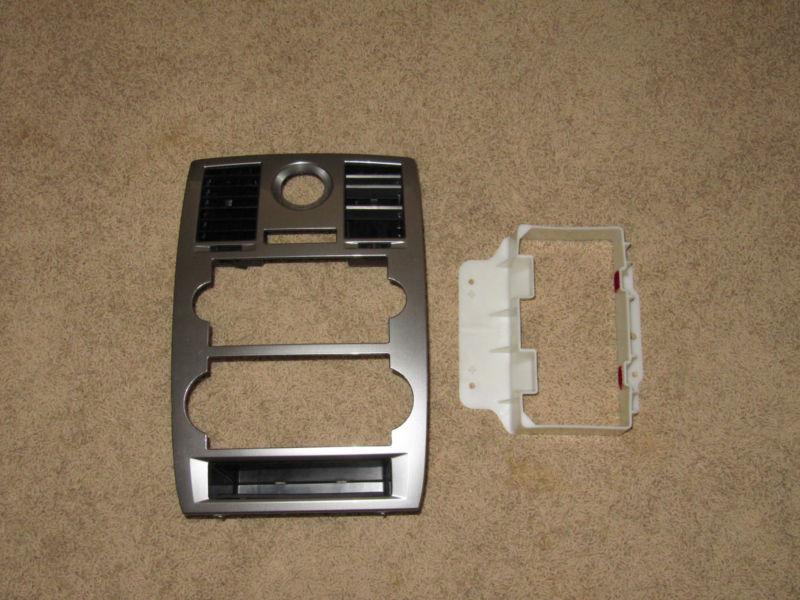 2006 chrysler 300 dash bezel, comes with stereo deck support and a/c vents