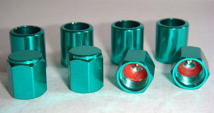 Set of 4 green aluminum alloy tire valve stem sleeves and hex top cap.