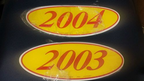 2 dozen yellow and red oval year stickers 1 dozen 2003 and 1 dozen 2004 dealer