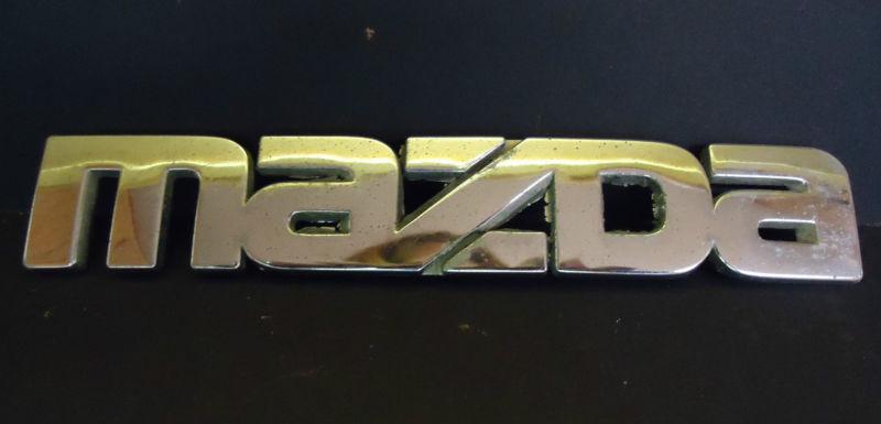 Used genuine oem "mazda" nameplate emblem / measures 6 1/2" x 1 1/8"