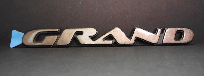 New oem gm pontiac "grand" am emblem lh /rh fr door 1997-2003 bronze 6 1/4"x5/8"