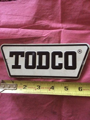 Todco metal stamped, embossed, self adhesive door logo emblem good used cond